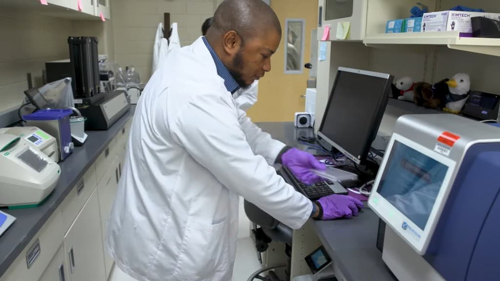 Researcher working with assay plates and instruments in the BioRacc laboratory